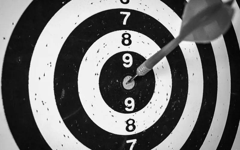 A bright red target with an arrow hitting the bullseye dead center